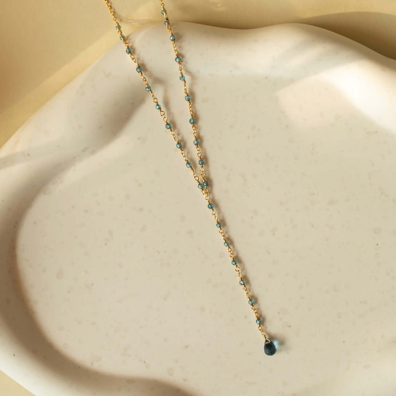 Against a clay plate backdrop, the lolite necklace showcases a calm and understated beauty—a simple scene of natural grace.