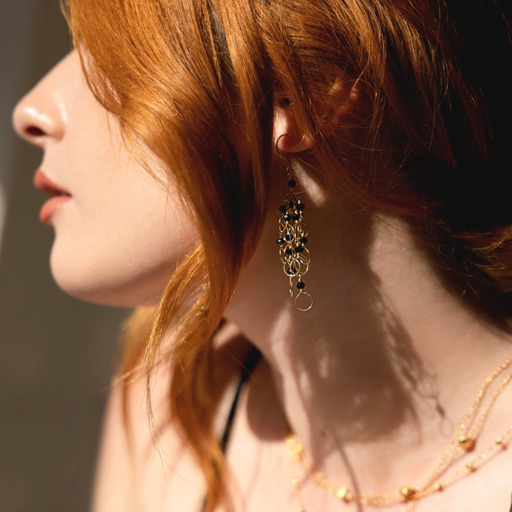 Profile of girl with red hair wearing black spinel chain look earrings by Parken Jewelry