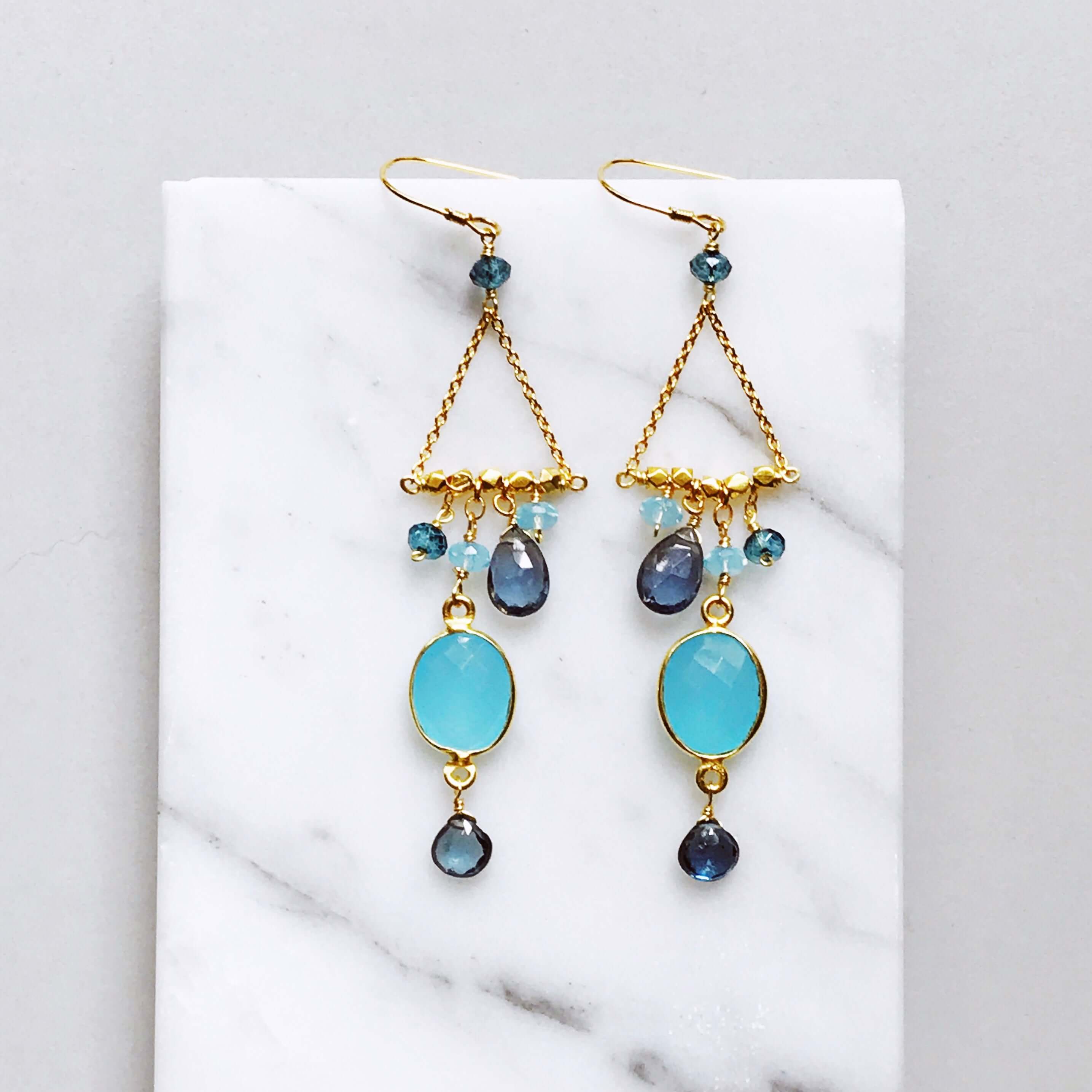 Bezel set blue chalcedony gemstones surrounded by faceted London Blue quartz accent stones Gold Earrings