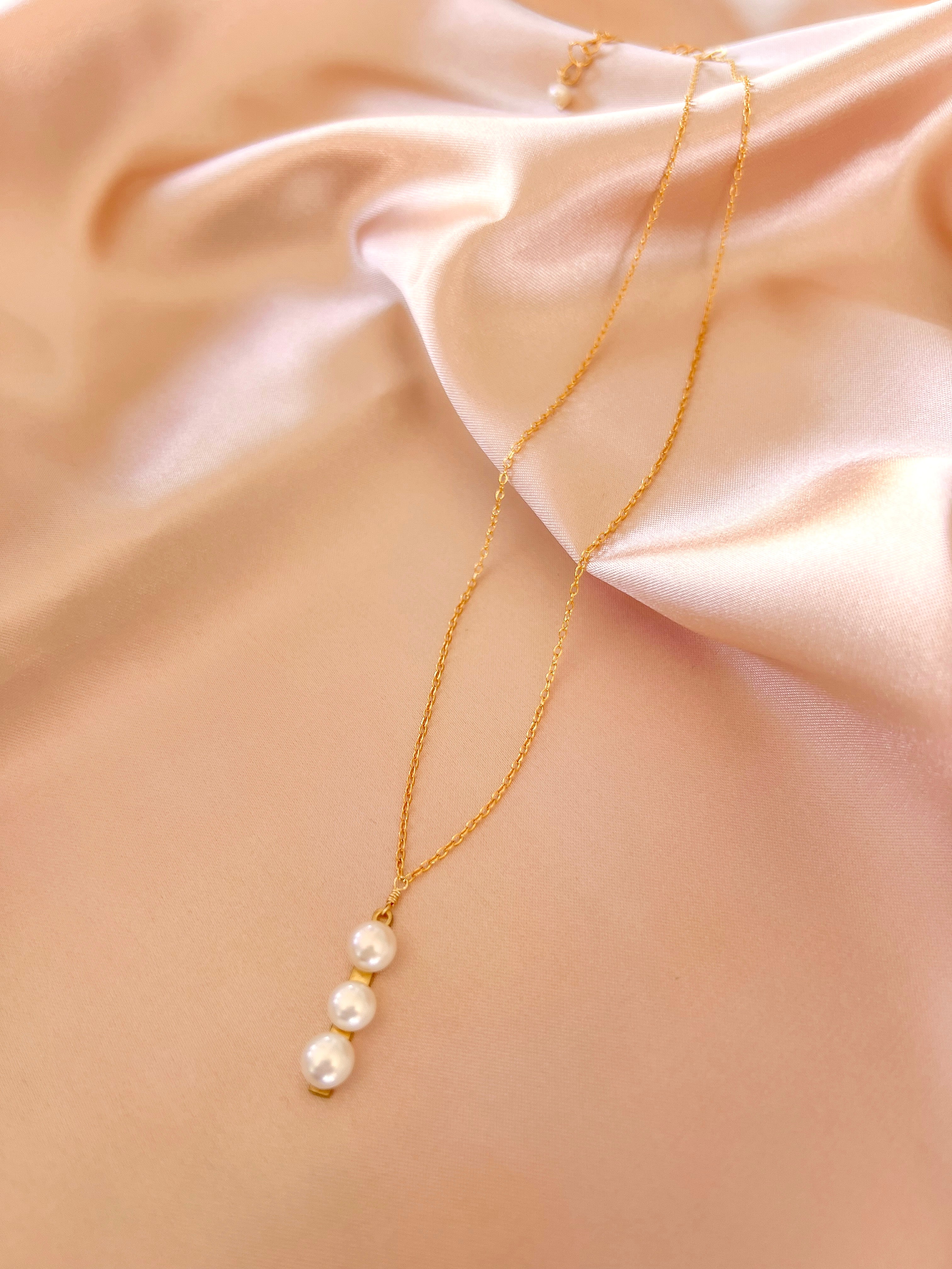 Necklace featuring three freshwater pearls on a slim gold bar, attached to a delicate 14k gold-plated chain