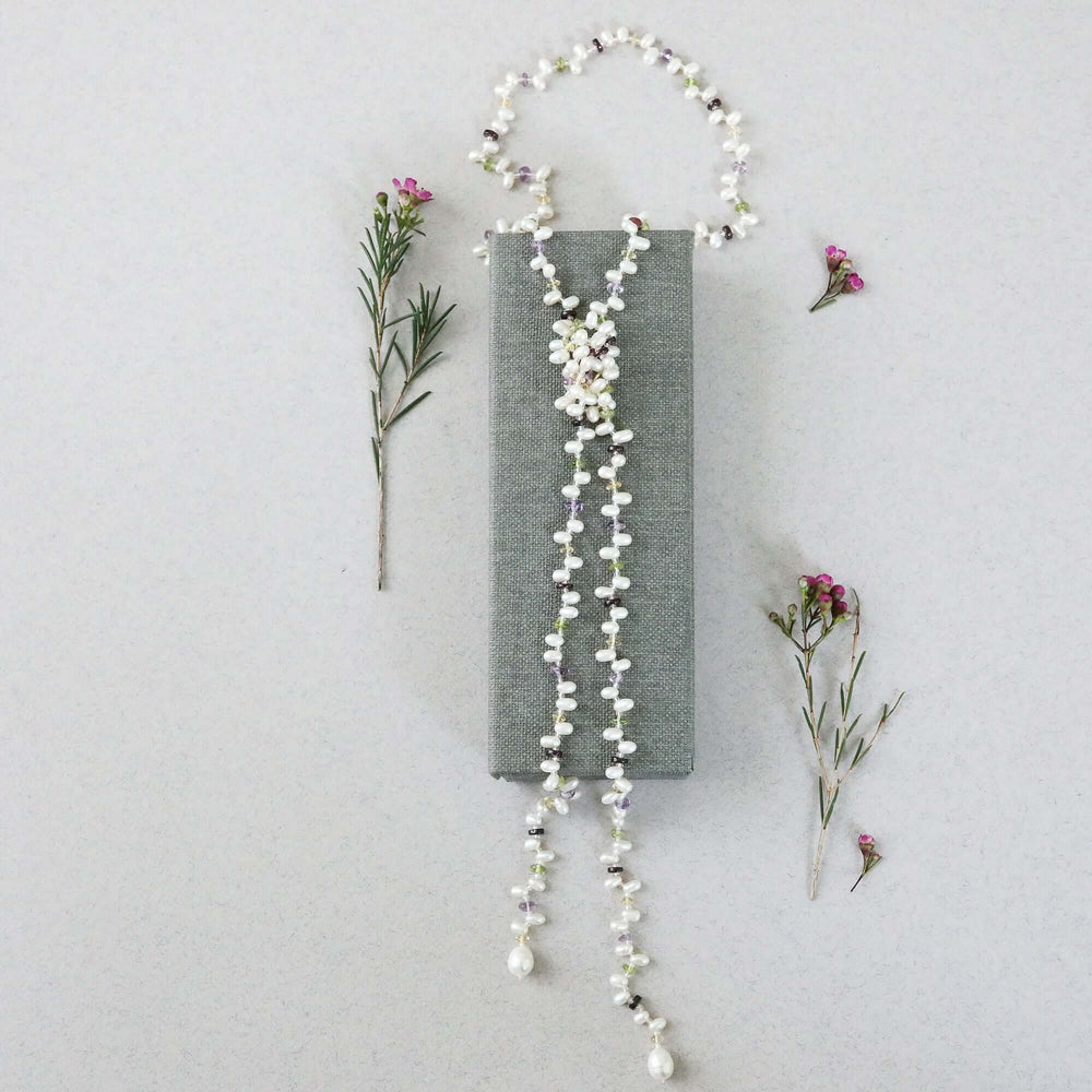 Lariat necklace with 45 inches of freshwater bead pearls and multi-colored gemstones, including garnet, peridot, amethyst, and champagne quartz
