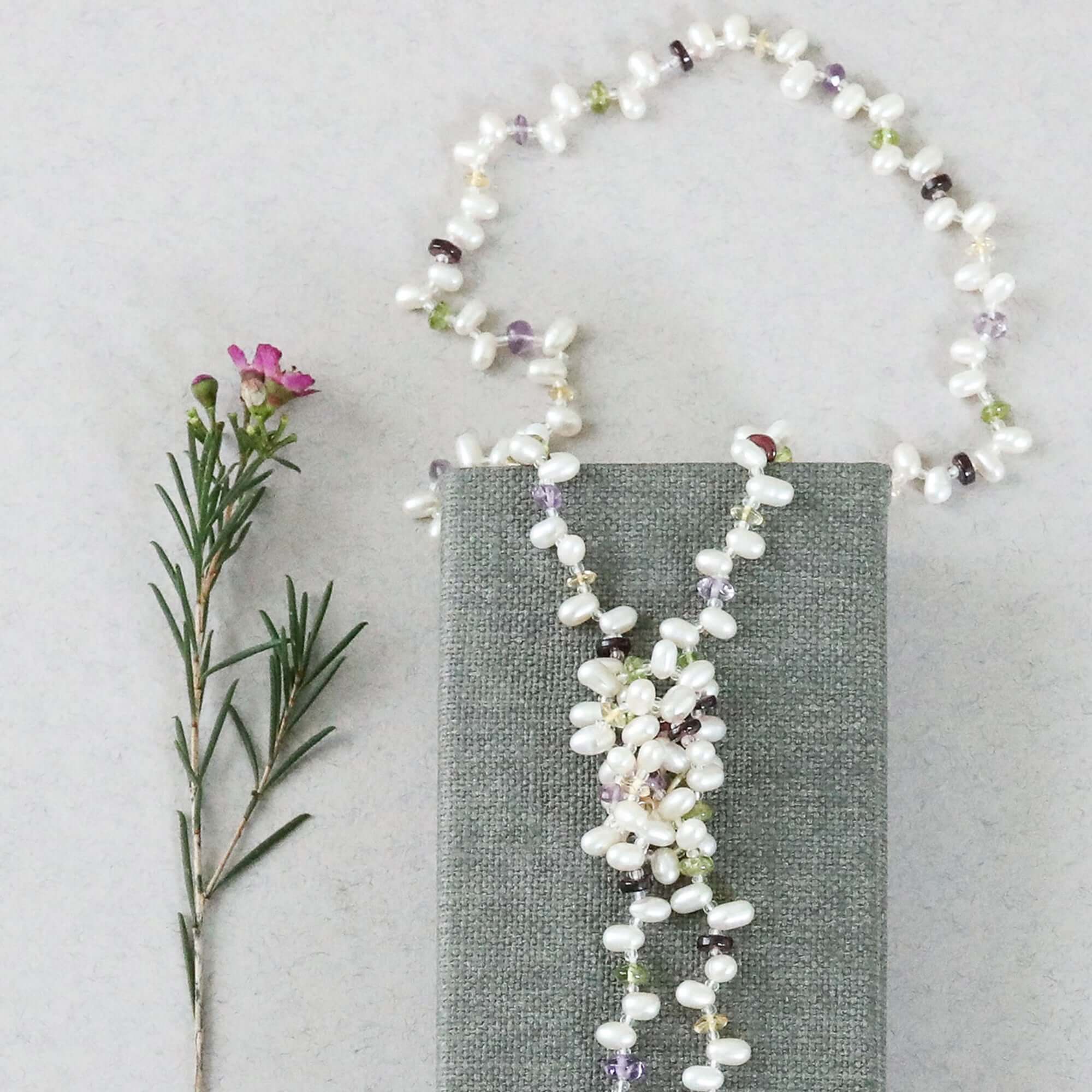 Lariat necklace with 45 inches of freshwater bead pearls and multi-colored gemstones, including garnet, peridot, amethyst, and champagne quartz