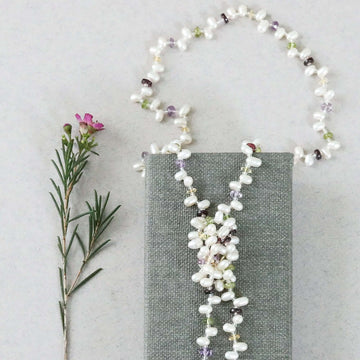 Lariat necklace with 45 inches of freshwater bead pearls and multi-colored gemstones, including garnet, peridot, amethyst, and champagne quartz