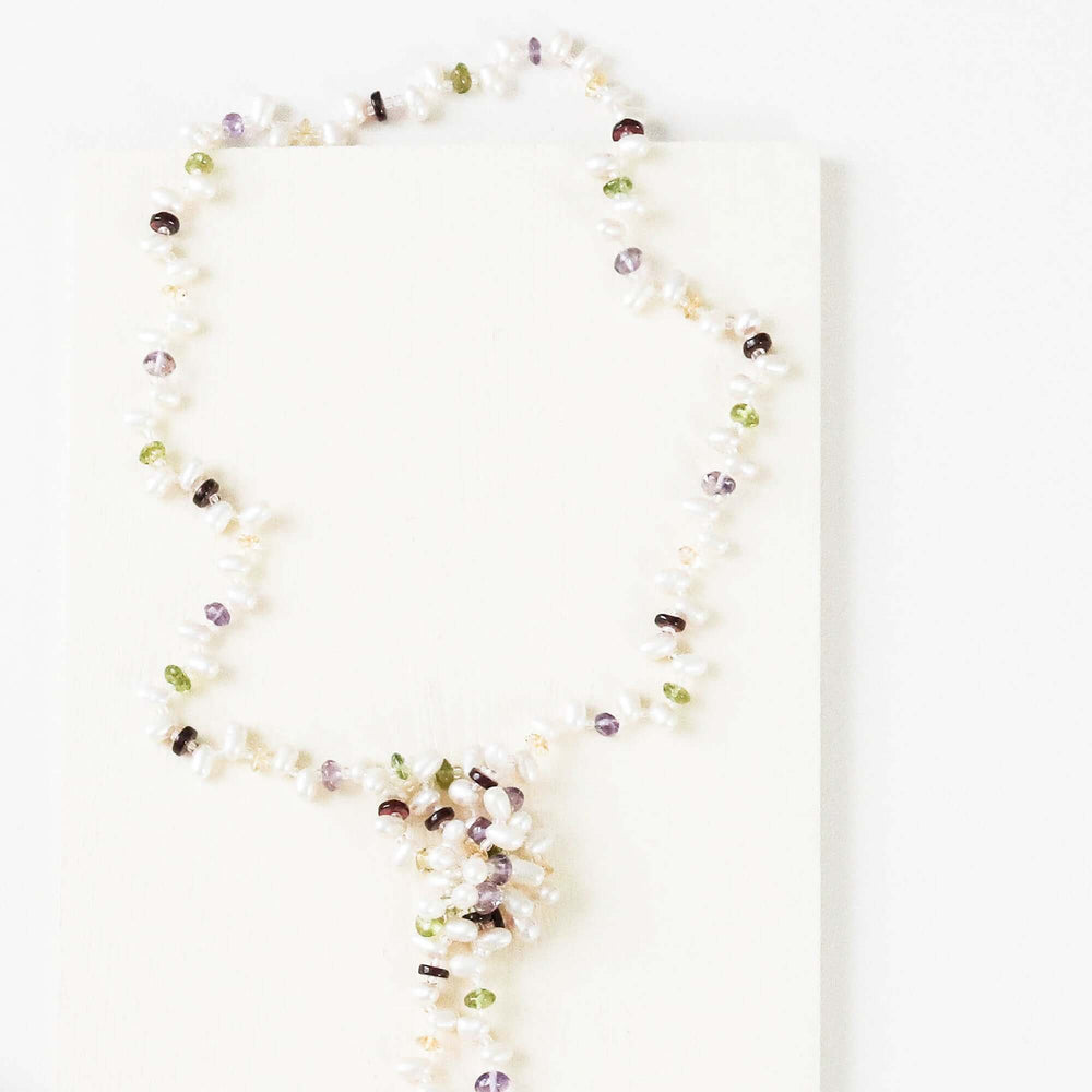 Lariat necklace with 45 inches of freshwater bead pearls and multi-colored gemstones, including garnet, peridot, amethyst, and champagne quartz