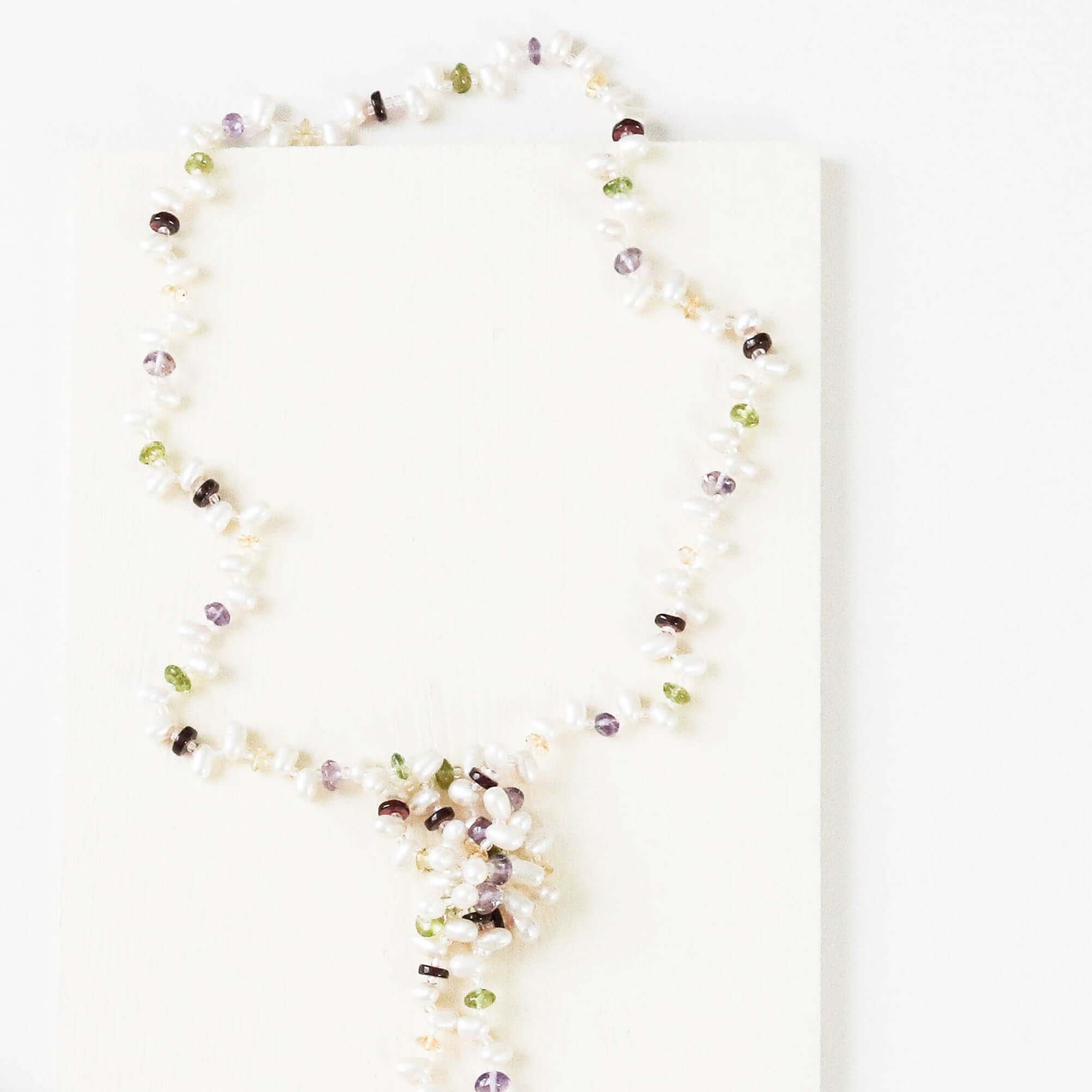 Lariat necklace with 45 inches of freshwater bead pearls and multi-colored gemstones, including garnet, peridot, amethyst, and champagne quartz