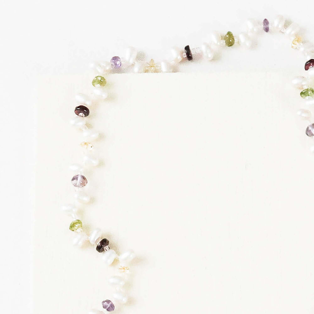 Lariat necklace with 45 inches of freshwater bead pearls and multi-colored gemstones, including garnet, peridot, amethyst, and champagne quartz