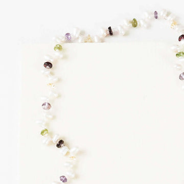 Lariat necklace with 45 inches of freshwater bead pearls and multi-colored gemstones, including garnet, peridot, amethyst, and champagne quartz