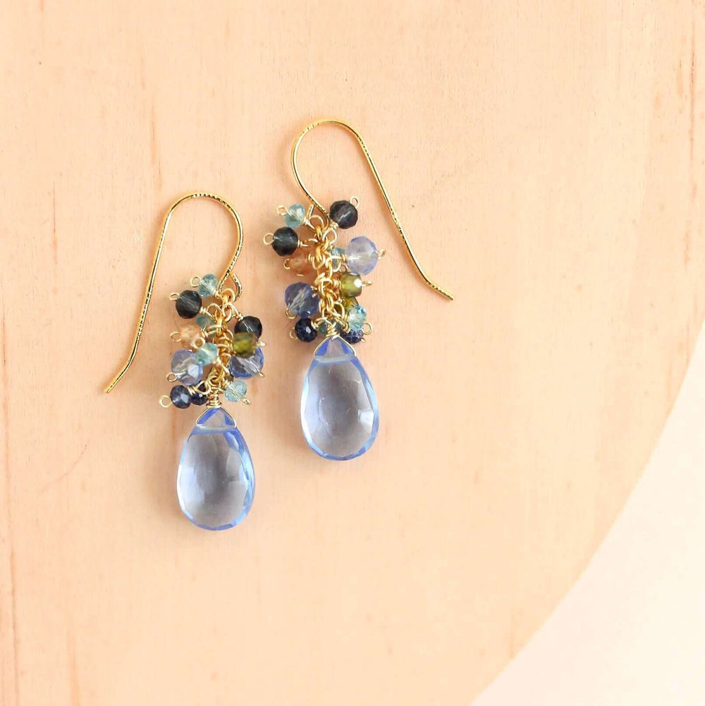 Gold drop earrings made with sky blue quartz topped with a blue cluster of gems