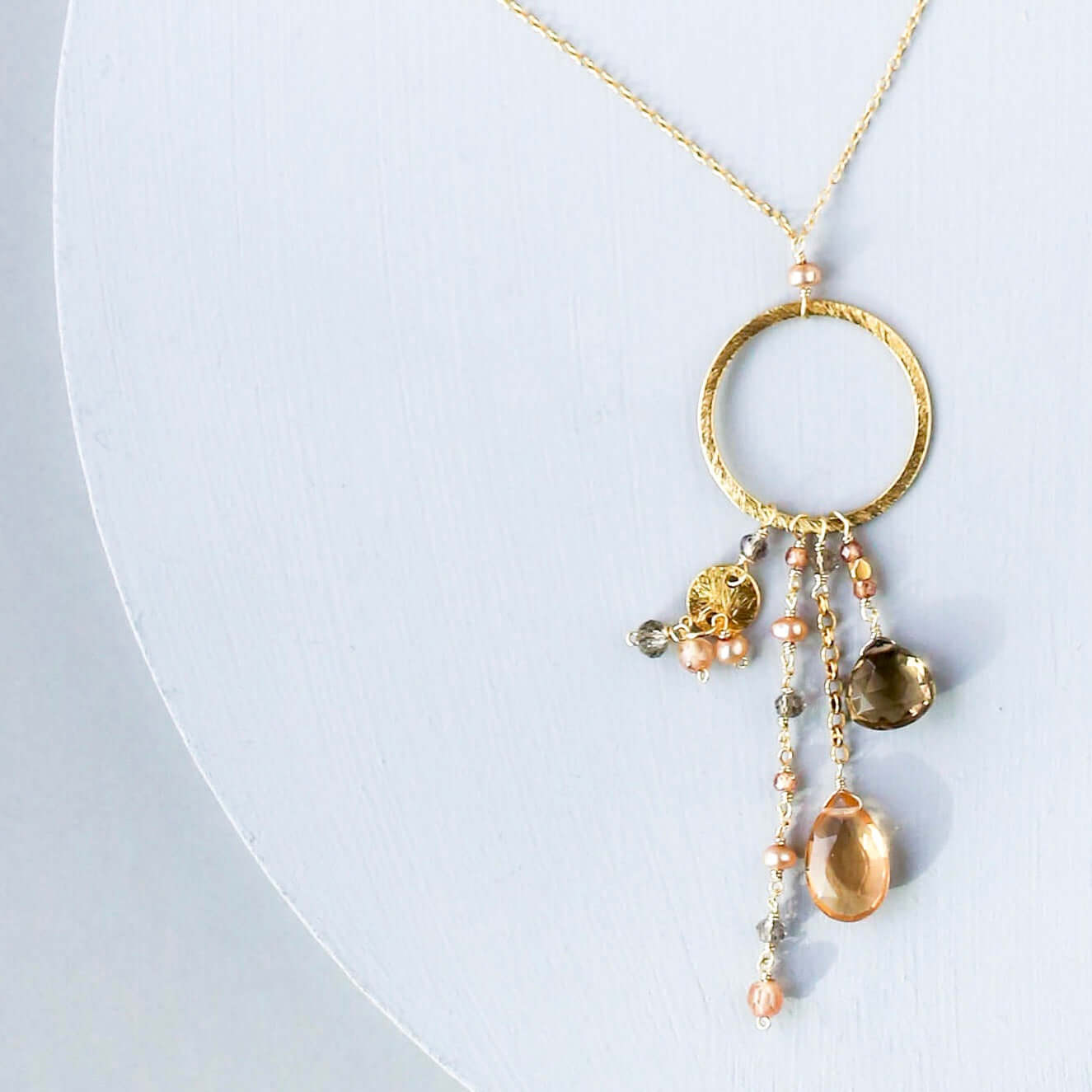 Multiple strands of lush gems sparkle on a hoop with citrine and smoky quartzt Gemstone Pendant Gold Necklace