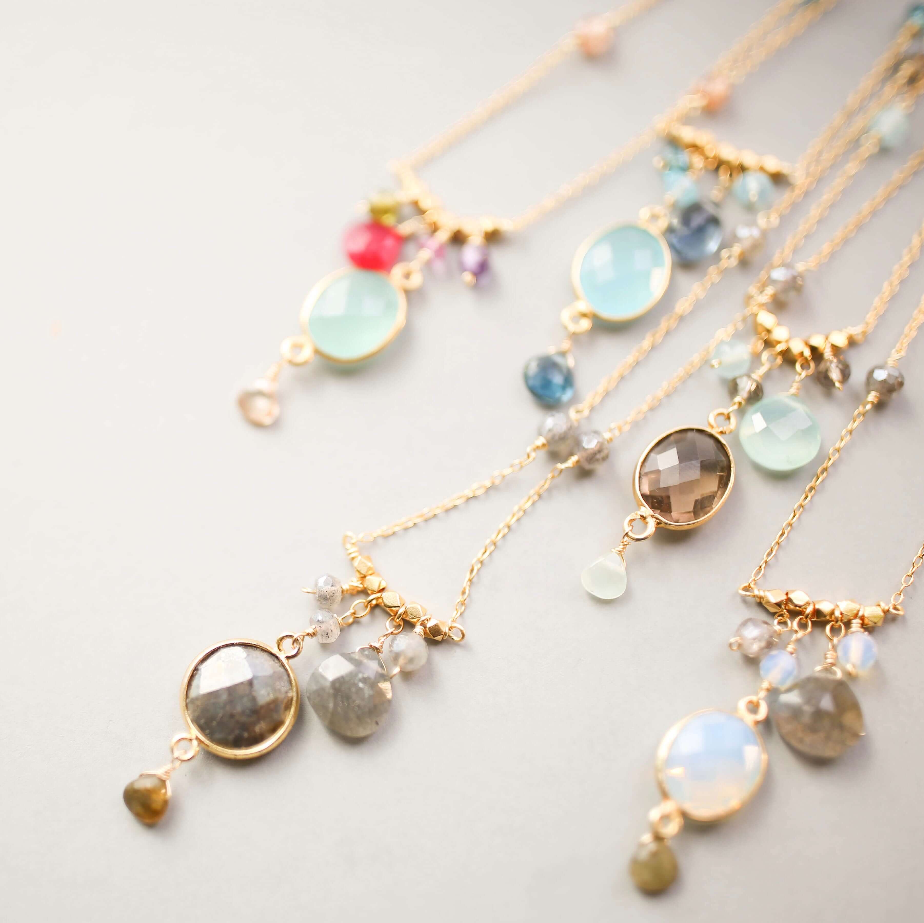 Elegant bezel-set  gemstones necklace with surrounding accents.