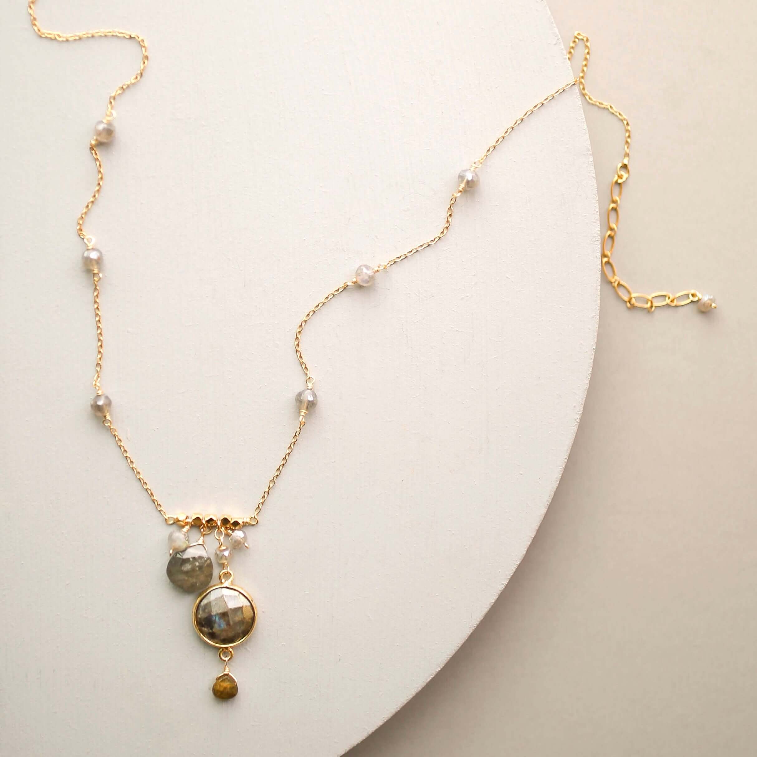 Elegant bezel-set labradorite gemstone necklace with surrounding accents.