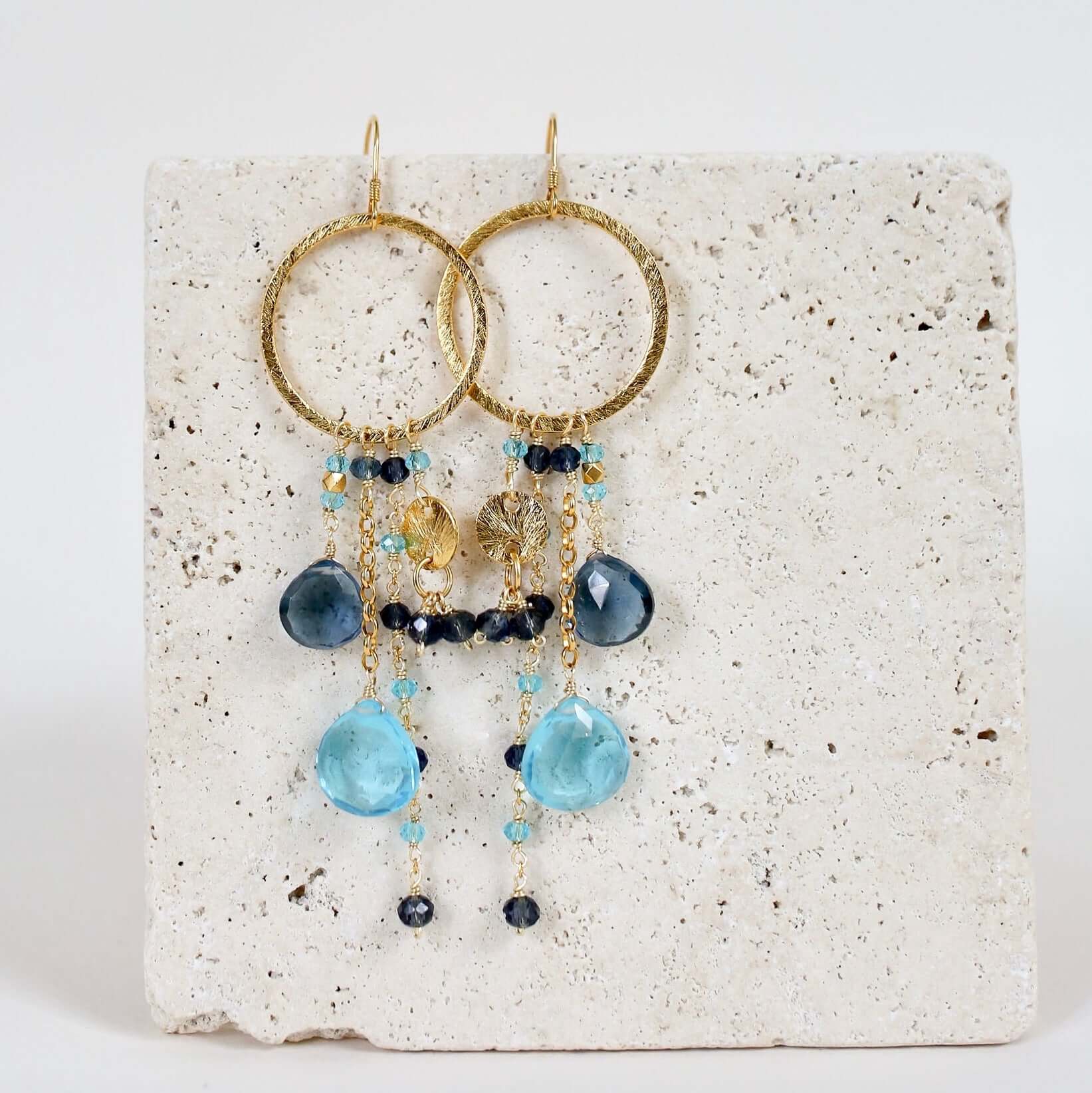 Multiple strands of lush gems sparkle on a hoop with Blue Gemstone Dangle Gold Earrings