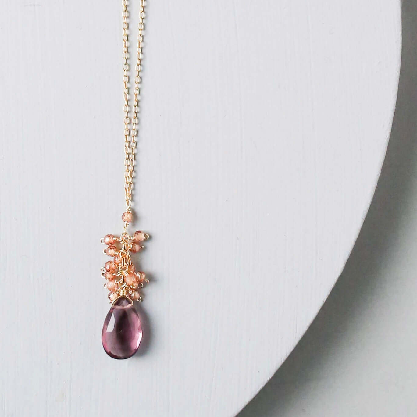 Vibrant rhodolite garnet gemstones paired with a cluster of mini champagne quartz gems Gold Necklace